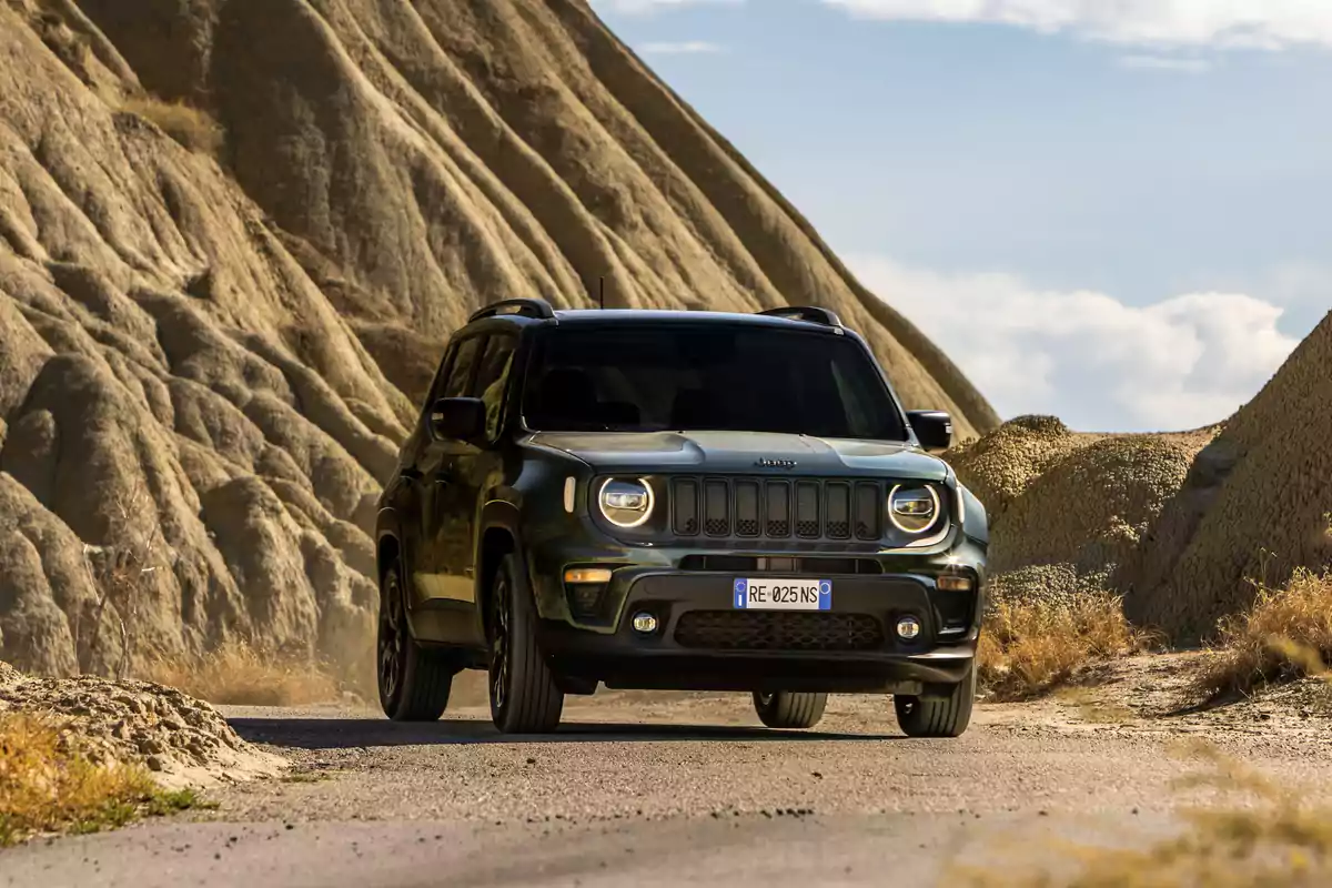 Un SUV North Star de Jeep negro circula por un camino rodeado de formaciones rocosas.