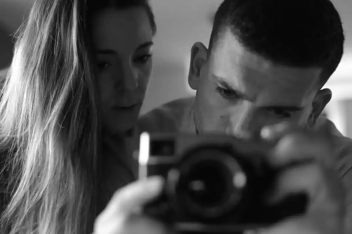 Pareja tomándose una selfie en blanco y negro con una cámara digital Pareja tomándose una selfie en blanco y negro con una cámara digital