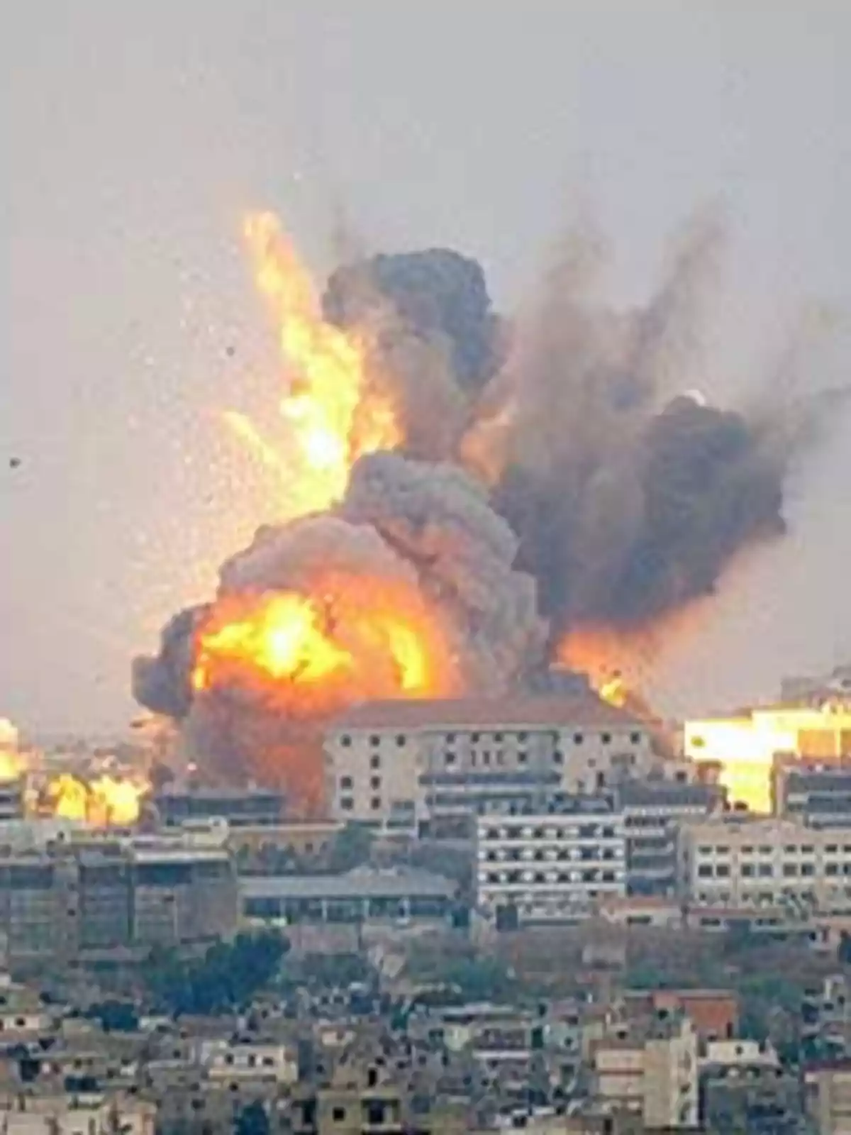 Explosión en un área urbana con edificios y humo denso.