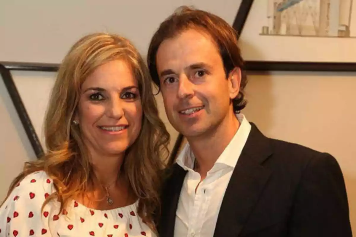 Una mujer y un hombre posando juntos y sonriendo frente a la cámara.