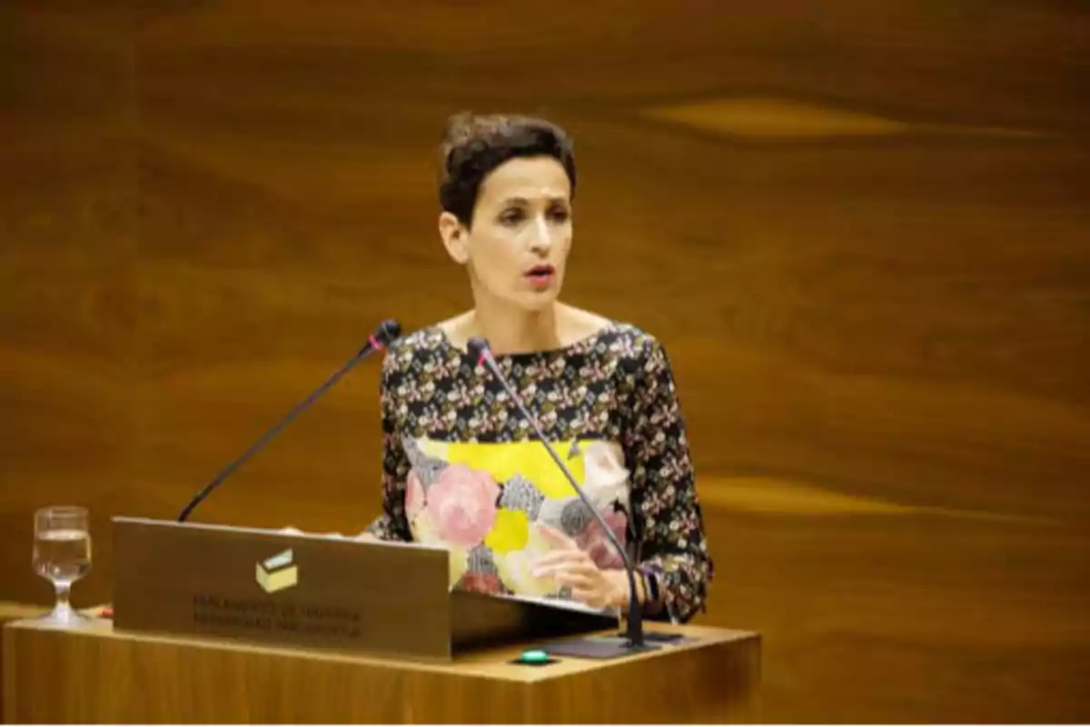 Mujer hablando en un podio en el Parlamento de Navarra