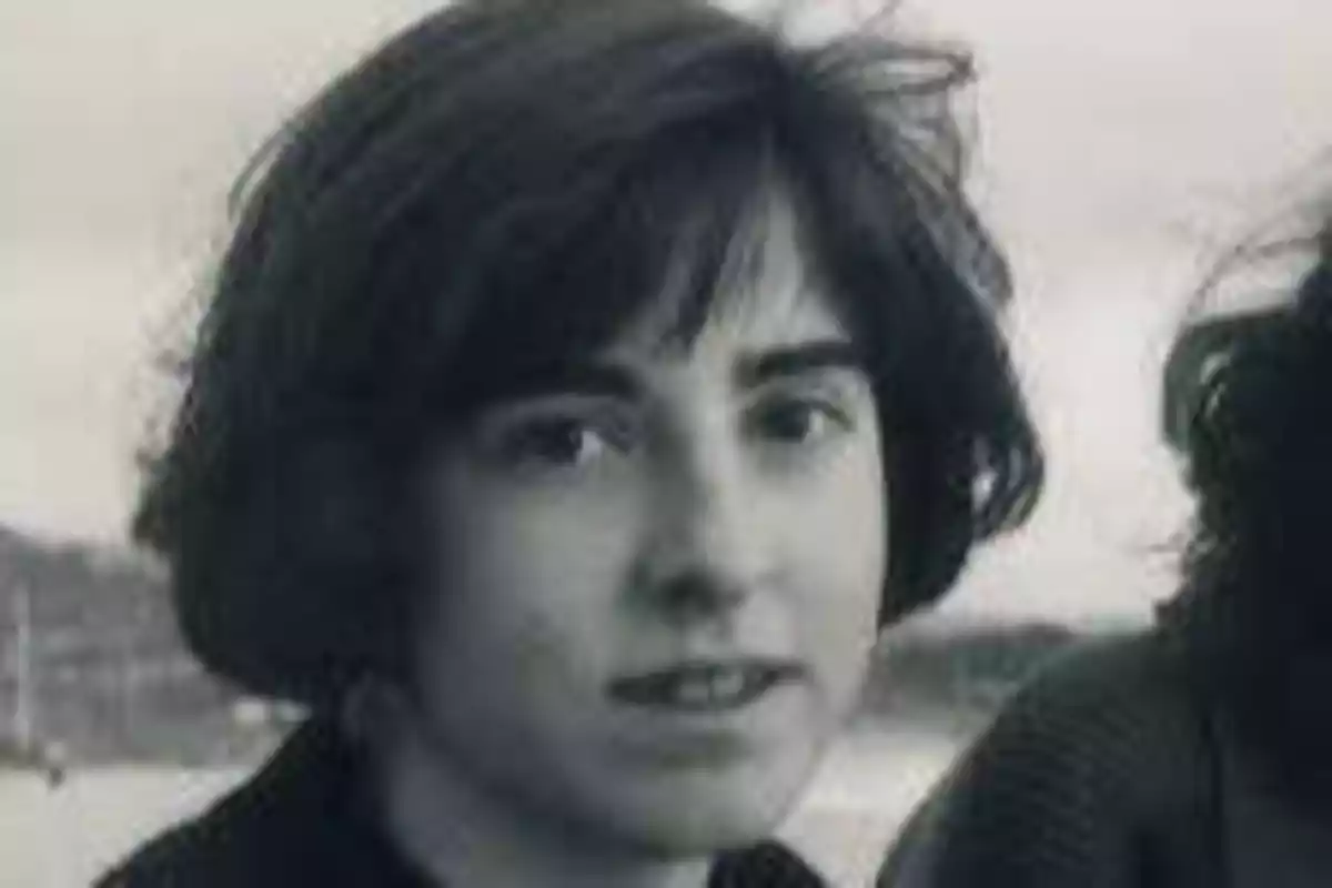 Una persona con cabello corto y oscuro mirando a la cámara en una fotografía en blanco y negro.