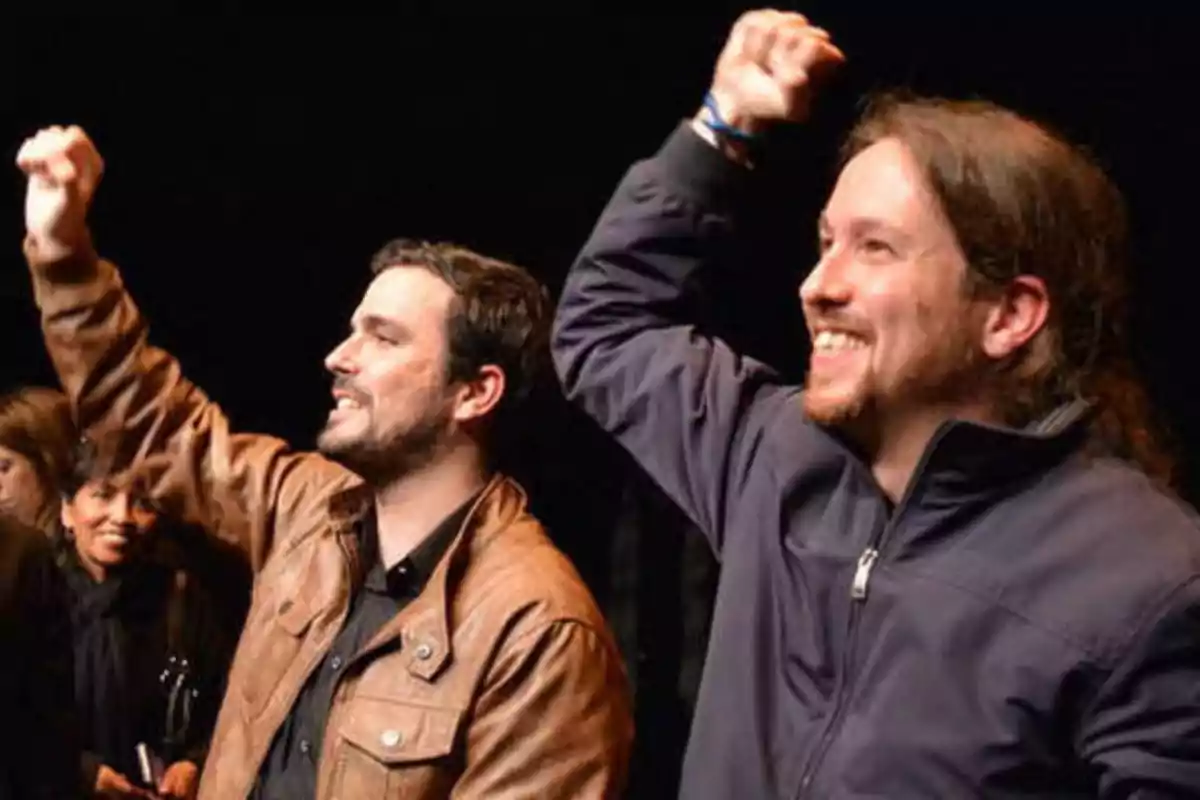 Dos hombres sonrientes levantando el puño en el aire en un evento.