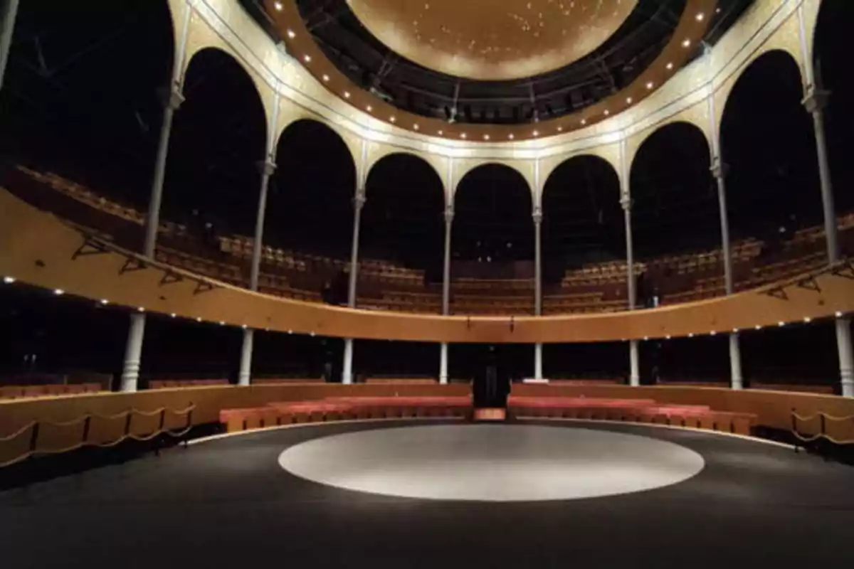 Interior de un teatro circular con columnas y asientos dispuestos en varios niveles.