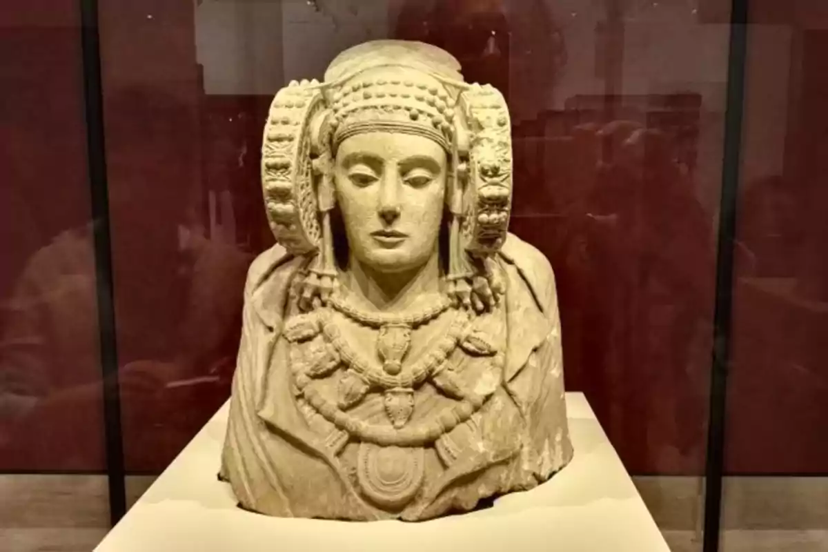 Escultura de la Dama de Elche en exhibición en un museo.