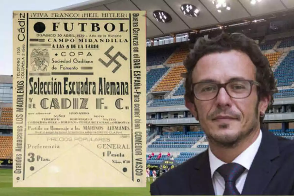 Un hombre con gafas y traje está de pie frente a un estadio de fútbol, junto a un cartel antiguo que anuncia un partido entre la Selección Escuadra Alemana y el Cádiz F.C.