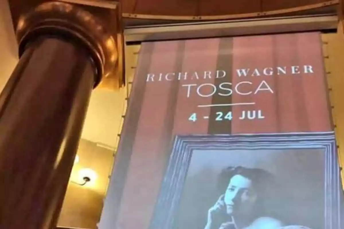 Cartel de la ópera "Tosca" de Richard Wagner, con fechas del 4 al 24 de julio, en el interior de un teatro con una columna decorativa en primer plano.