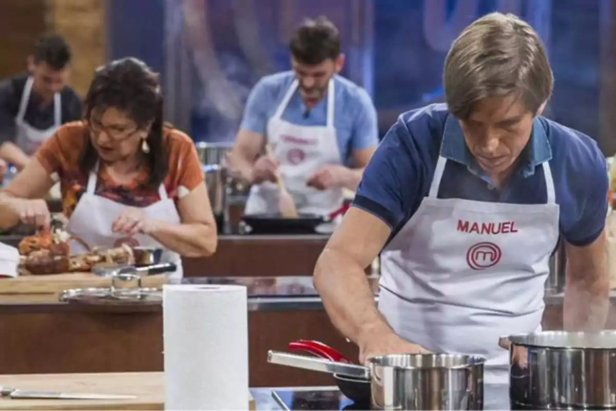 Personas cocinando en una competencia culinaria, usando delantales blancos con nombres.