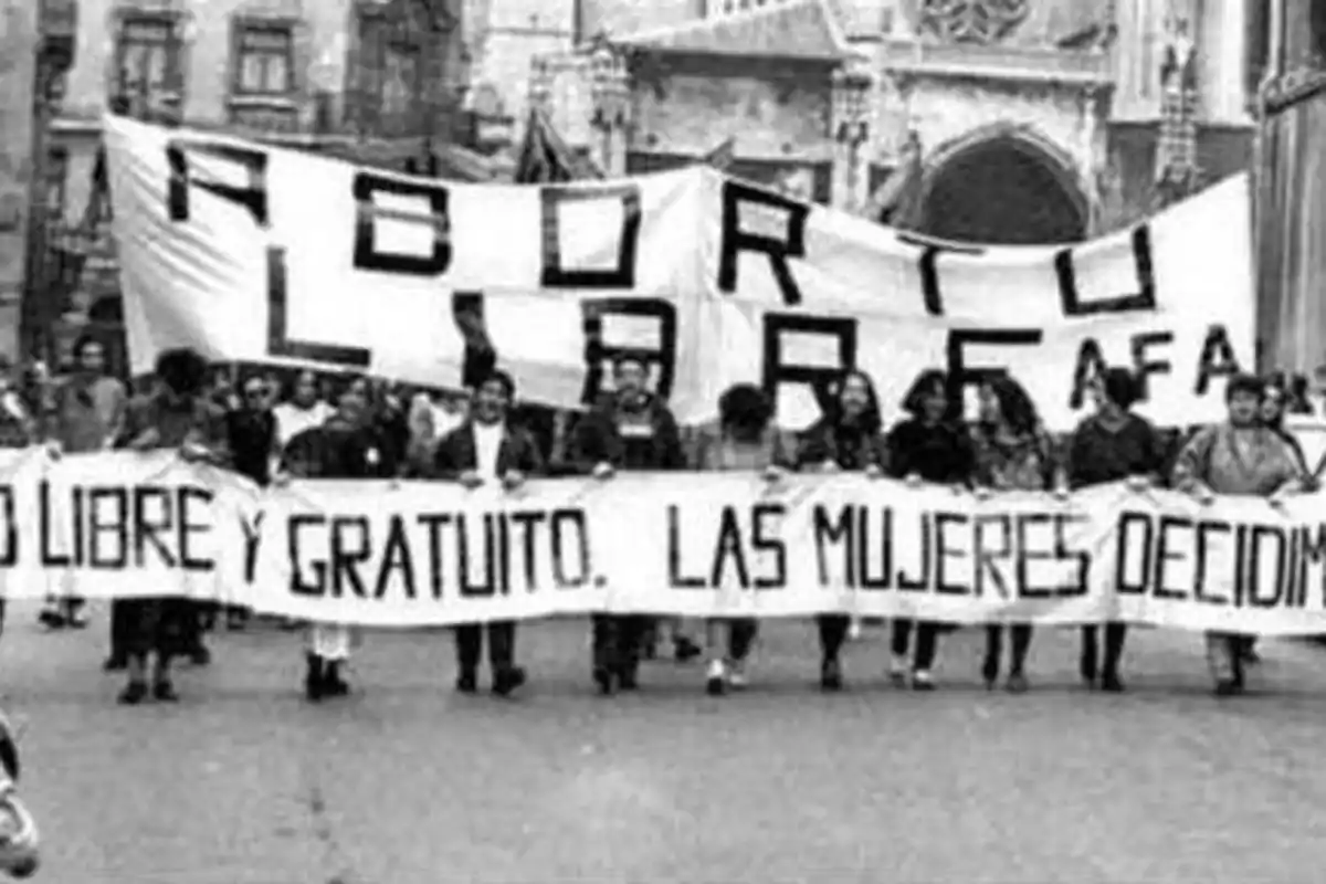 Un grupo de personas marcha sosteniendo pancartas que dicen "Aborto libre y gratuito. Las mujeres decidimos".