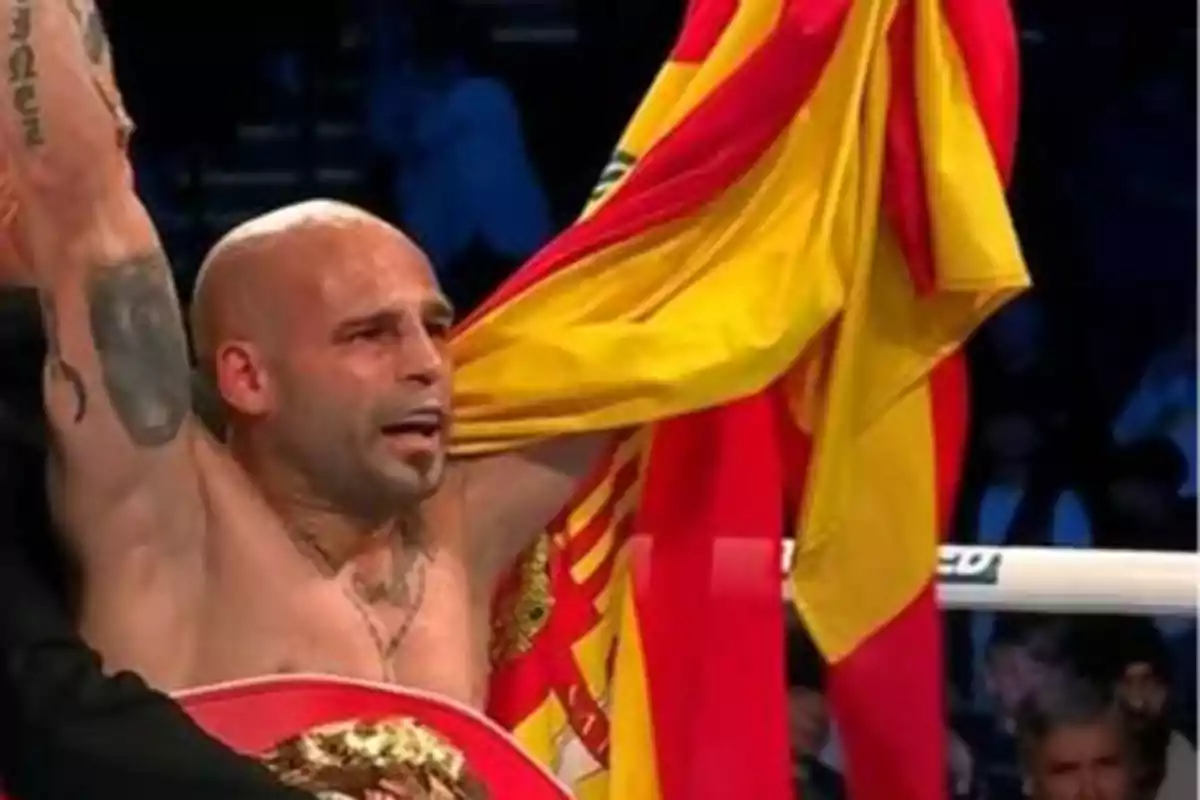 Un boxeador celebrando su victoria con una bandera de España.