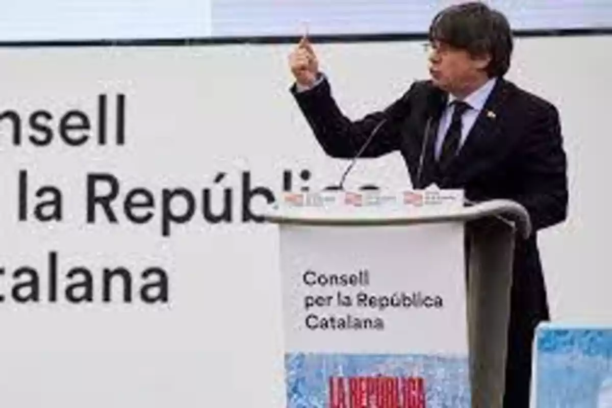 Un hombre hablando en un podio con el texto "Consell per la República Catalana" en el fondo.