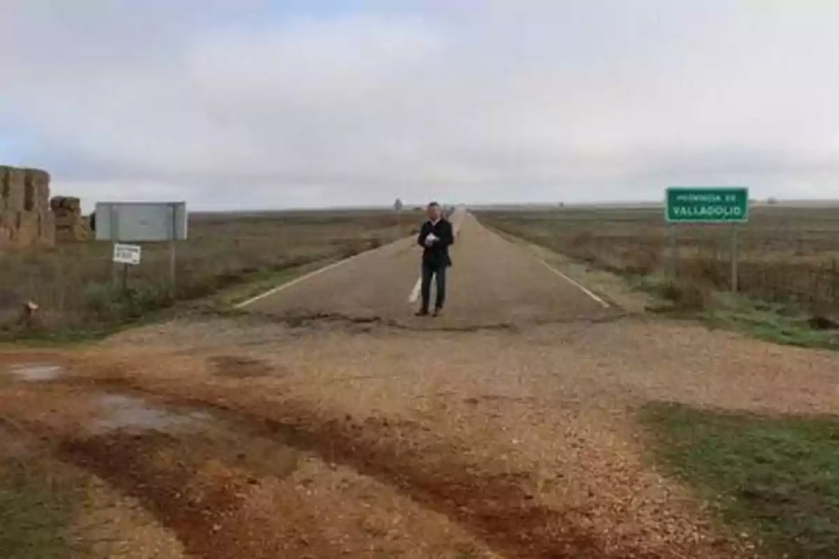 Persona de pie en una carretera desierta con un cartel que indica la provincia de Valladolid.