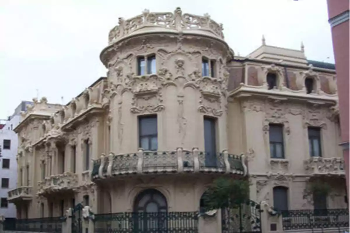 Edificio histórico con detalles arquitectónicos ornamentados y balcones de hierro forjado.