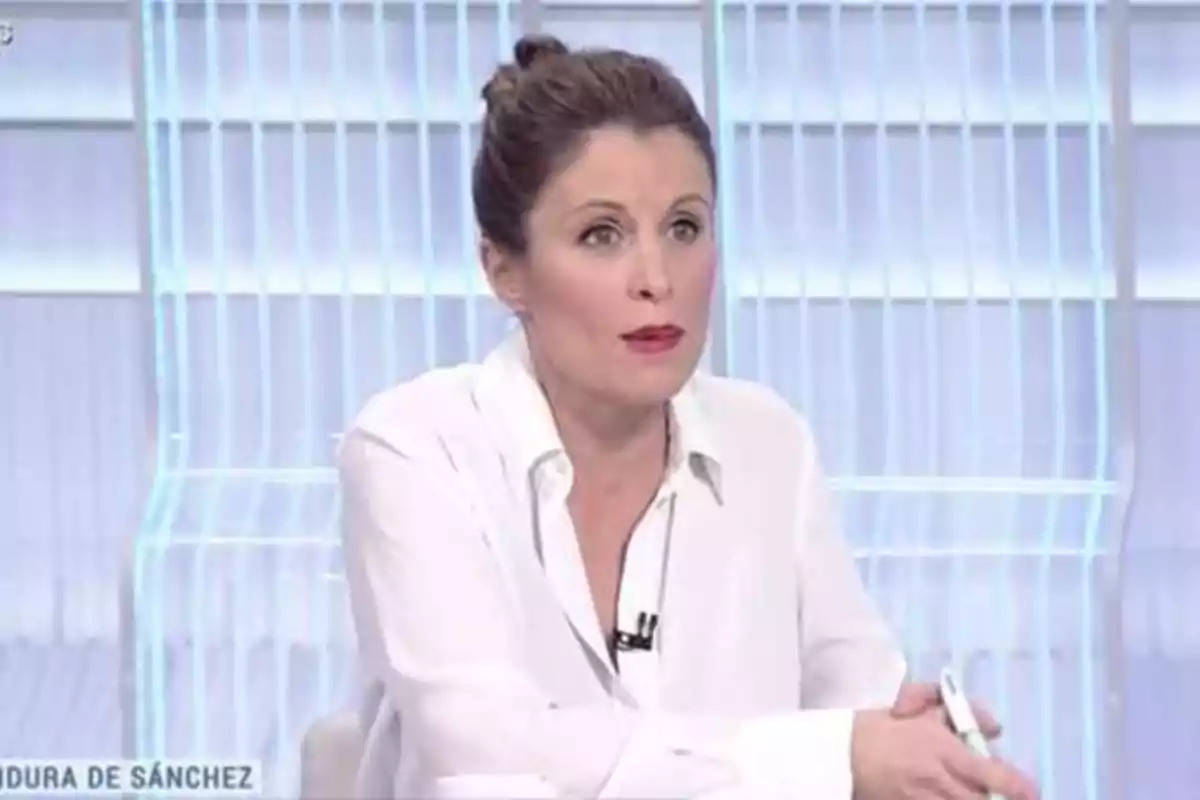 Mujer con camisa blanca hablando en un programa de televisión.