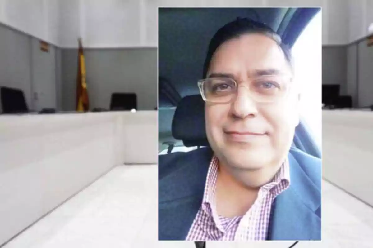 Un hombre con gafas y camisa a cuadros aparece en una foto superpuesta sobre la imagen de una sala de conferencias o tribunal.