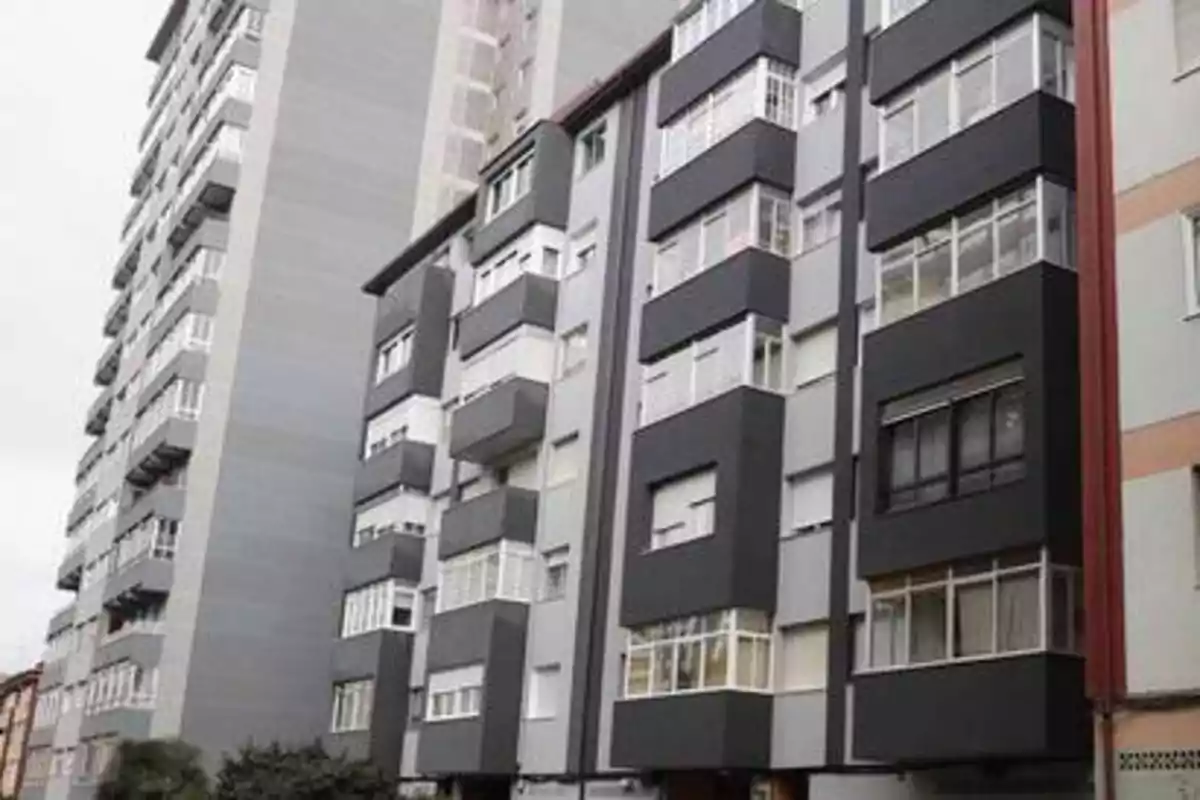 Edificios de apartamentos de varios pisos con fachadas grises y negras.