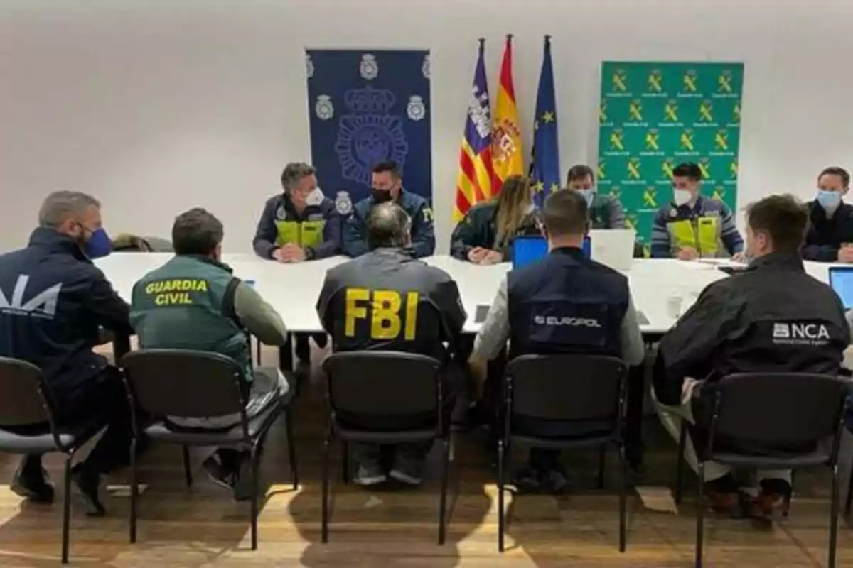 Reunión de agentes de diversas agencias de seguridad en una sala de conferencias.