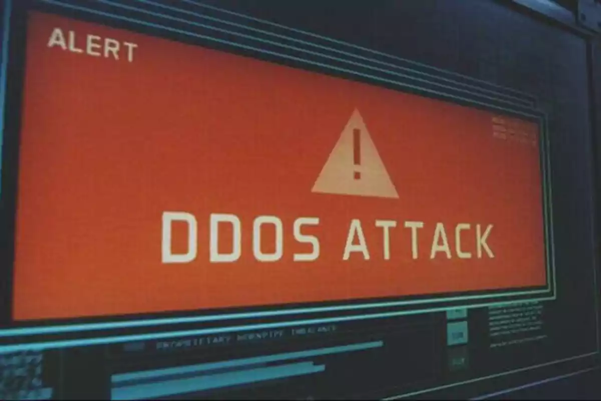 Pantalla de alerta mostrando un mensaje de "DDOS ATTACK" en letras grandes y un símbolo de advertencia.