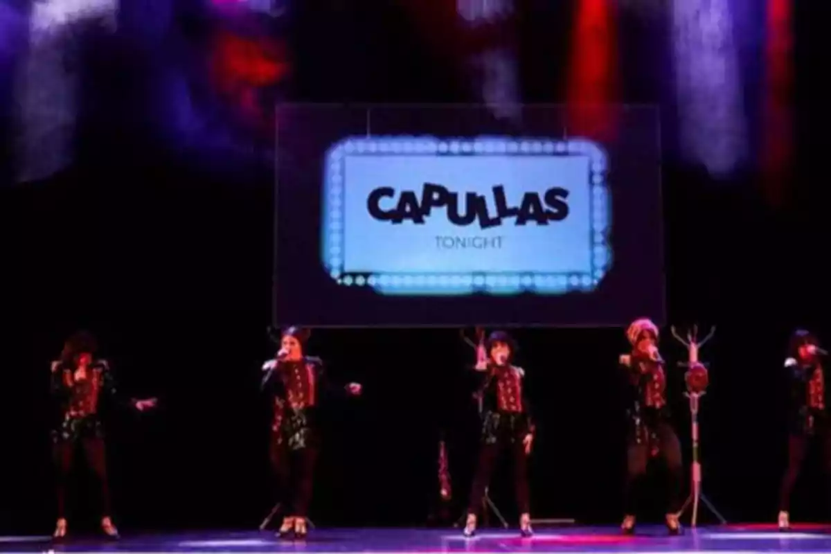 Un grupo de personas en el escenario con un cartel que dice "CAPULLAS TONIGHT" en el fondo.