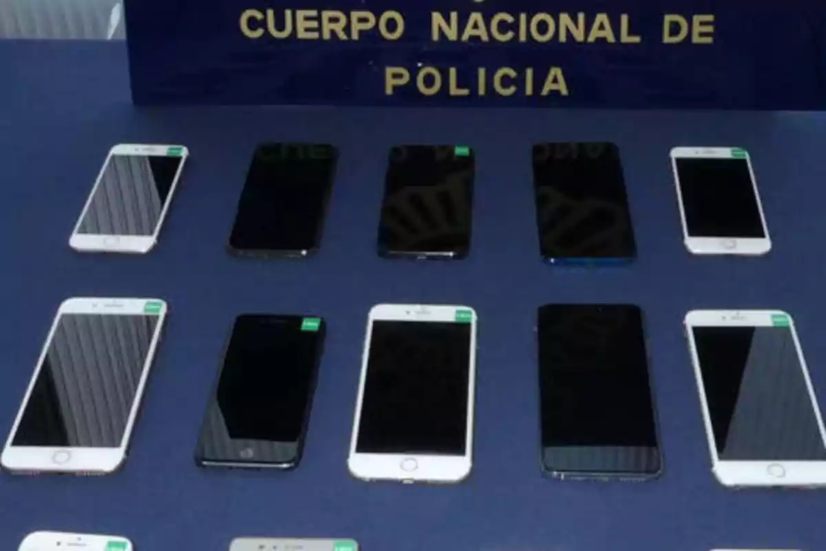 Varios teléfonos móviles incautados por el Cuerpo Nacional de Policía están dispuestos sobre una mesa.