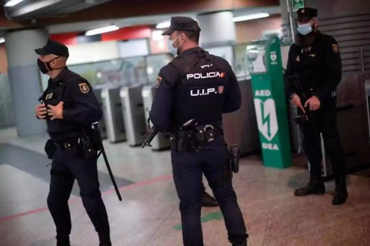 Policías con mascarillas patrullando una estación de metro.