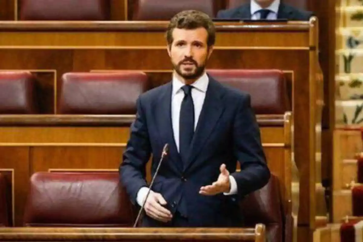 Un hombre de traje y corbata hablando en un parlamento.