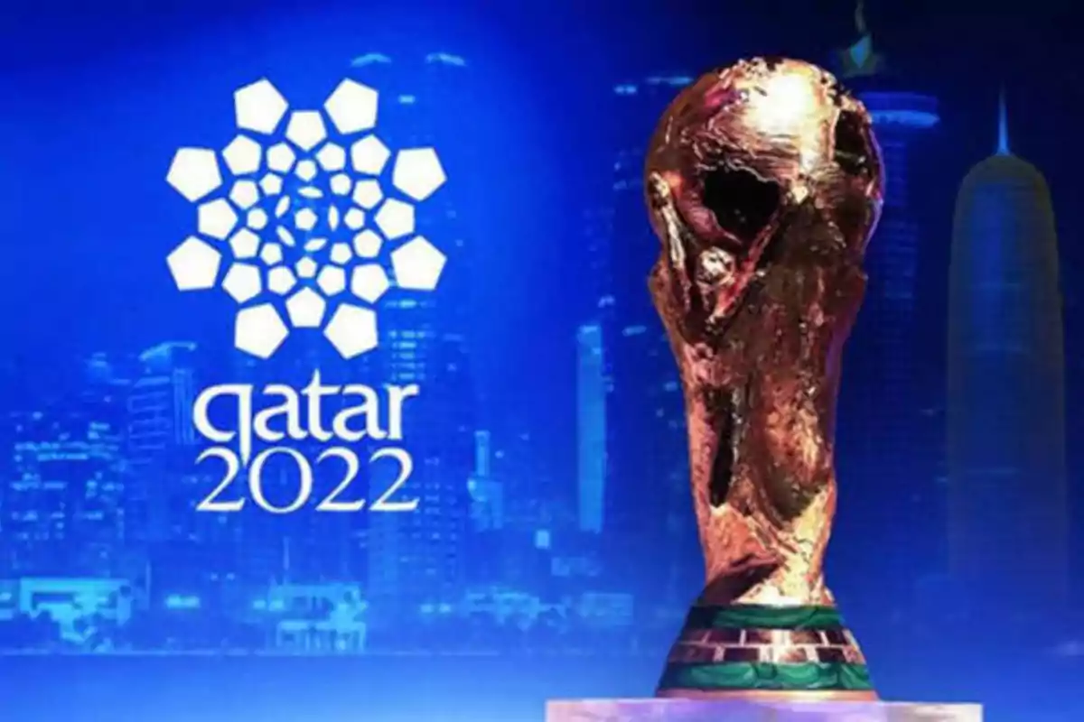 Trofeo de la Copa Mundial de la FIFA con el logo de Qatar 2022 en el fondo.