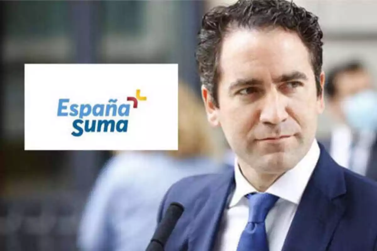 Hombre con traje y corbata azul junto a un logotipo que dice "España Suma".