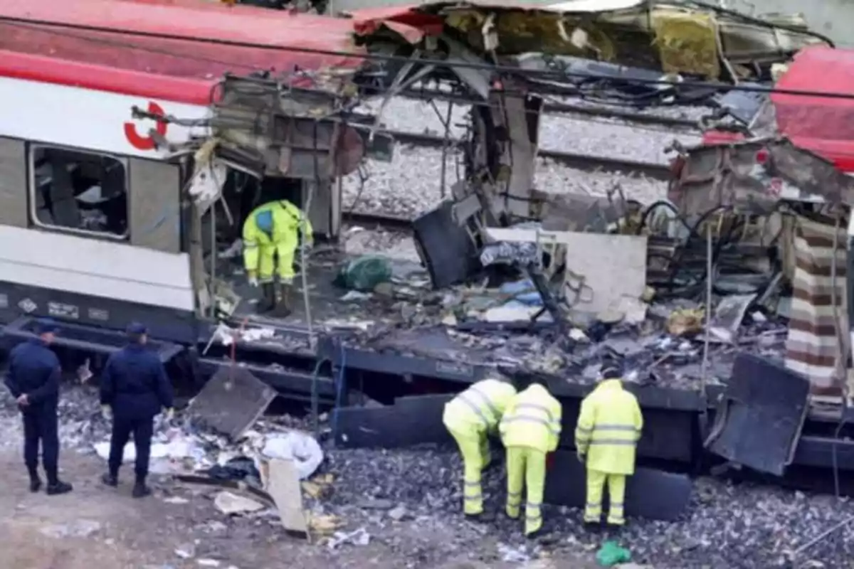 Investigadores y personal de emergencia inspeccionan los restos de un tren dañado.