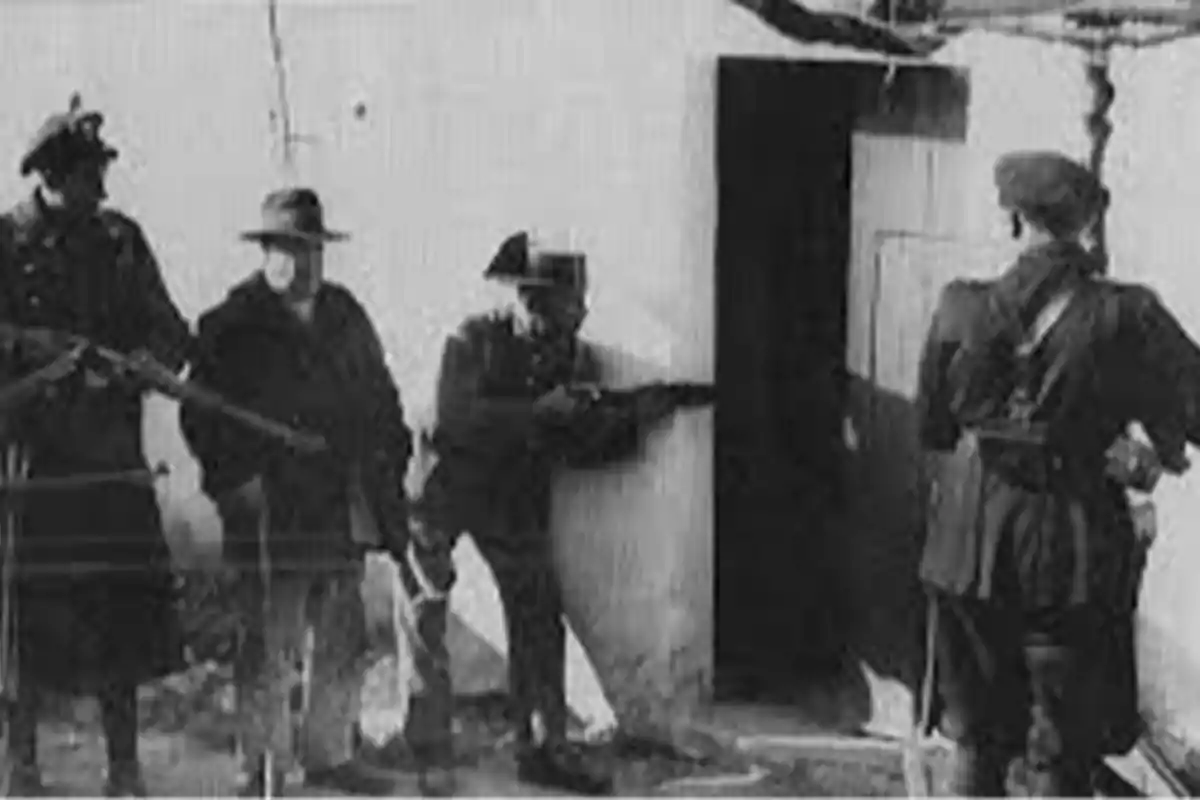 Un grupo de hombres armados en uniforme militar se encuentra frente a la entrada de un edificio.