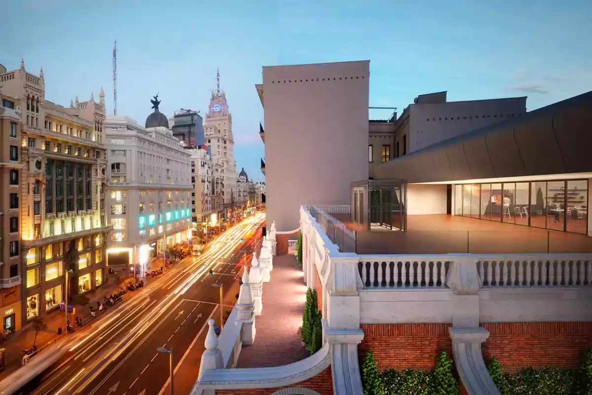 Vista panorámica de una avenida iluminada al atardecer con edificios históricos y una terraza moderna en primer plano Vista panorámica de una avenida iluminada al atardecer con edificios históricos y una terraza moderna en primer plano
