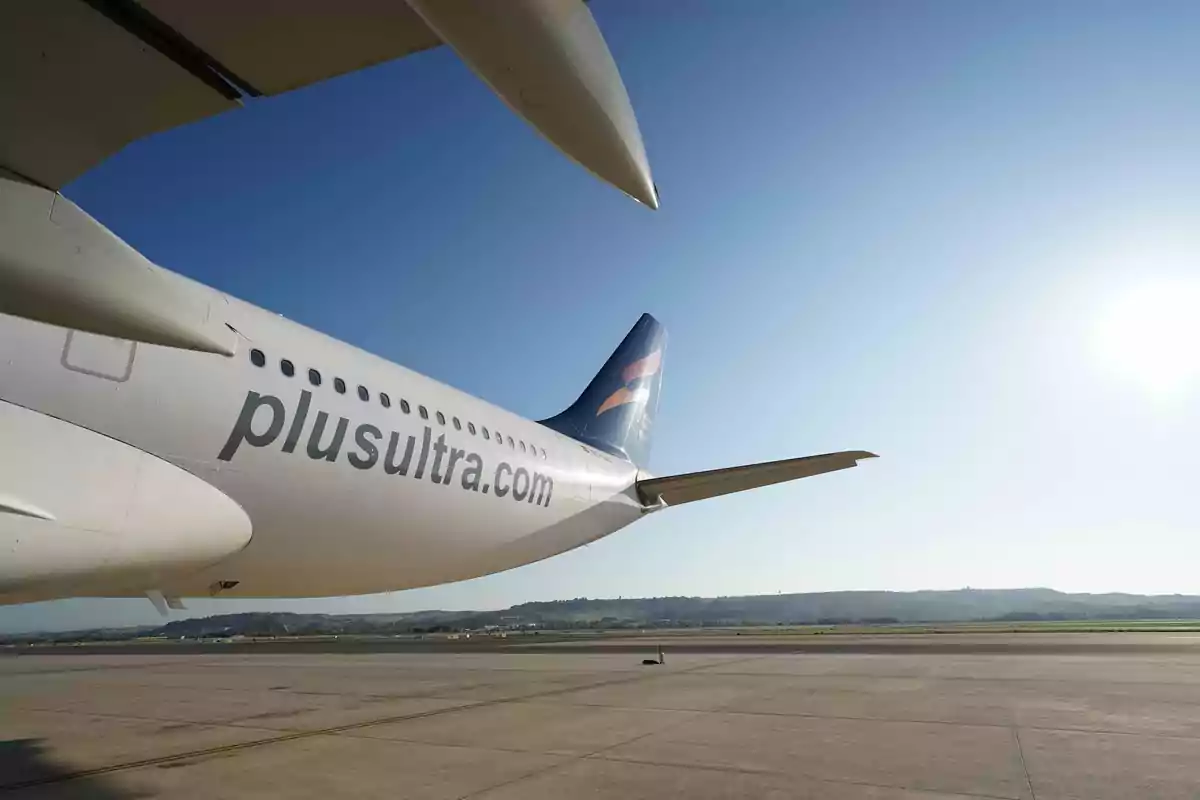 Avión de la aerolínea Plus Ultra estacionado en la pista de un aeropuerto bajo un cielo despejado