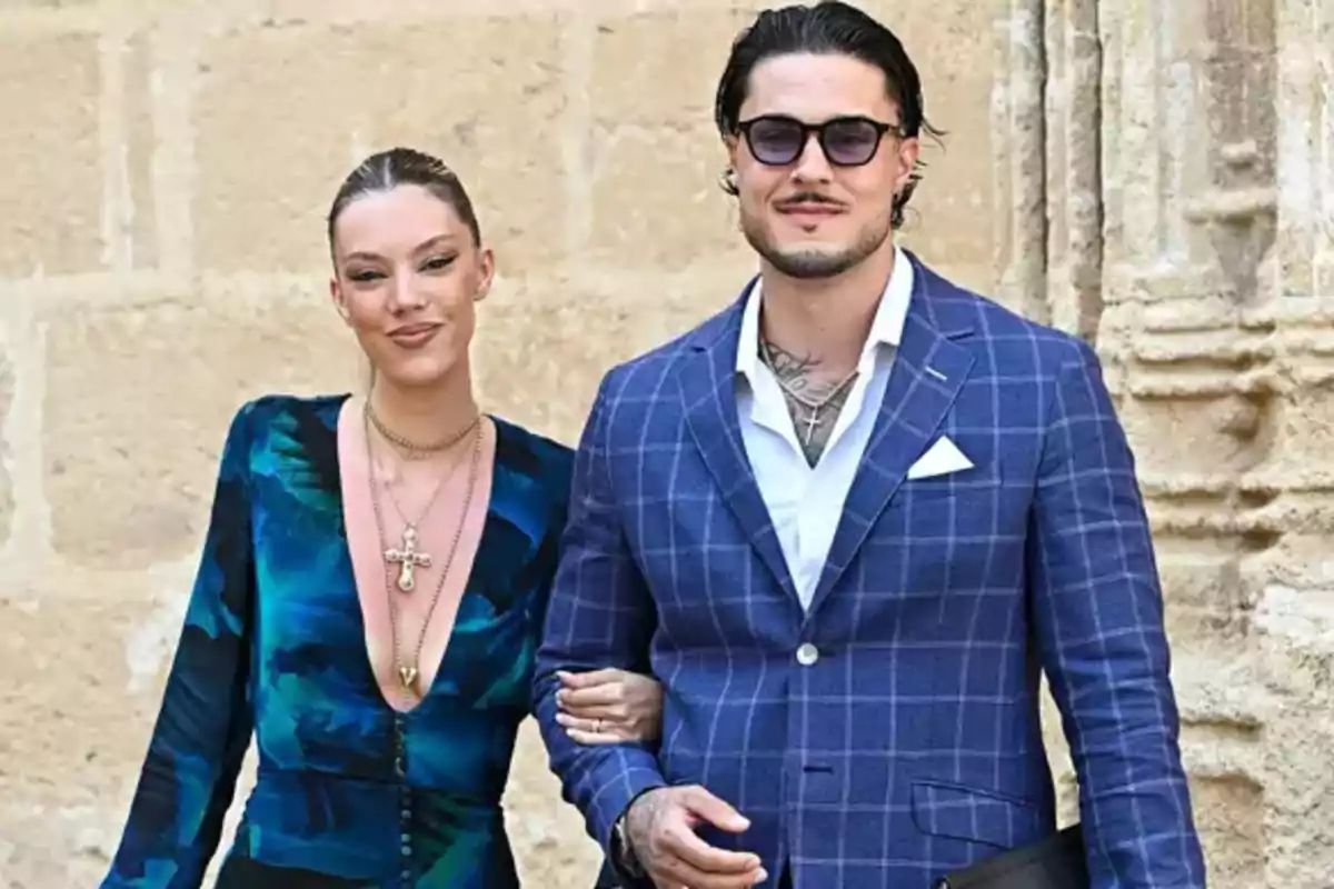 Alejandra Rubio y Carlo Costanzia posan frente a una pared de piedra, ella lleva un vestido azul con estampado y él un traje azul con cuadros y gafas de sol. Alejandra Rubio y Carlo Costanzia posan frente a una pared de piedra, ella lleva un vestido azul con estampado y él un traje azul con cuadros y gafas de sol.