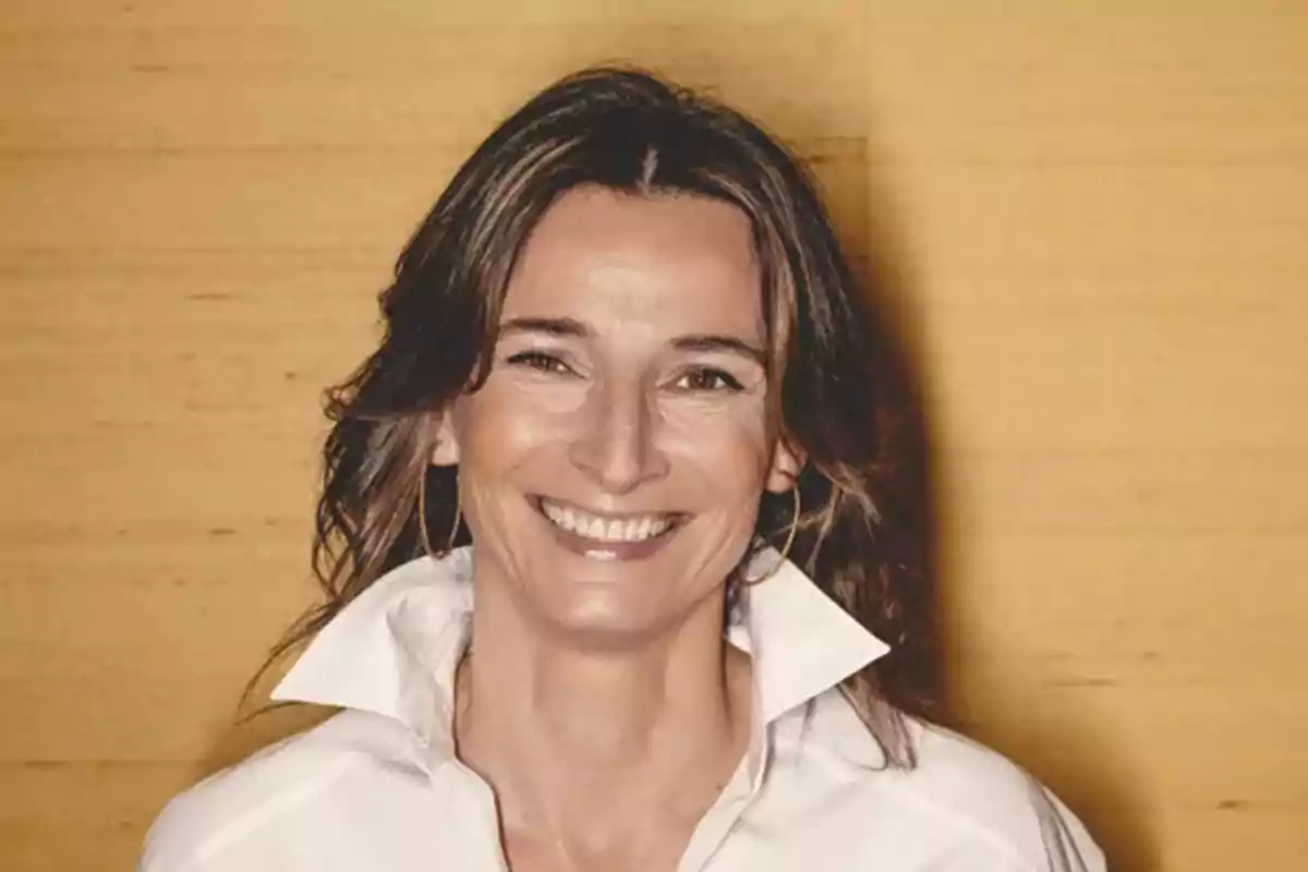 Mujer sonriente de cabello castaño con camisa blanca y fondo amarillo Mujer sonriente de cabello castaño con camisa blanca y fondo amarillo