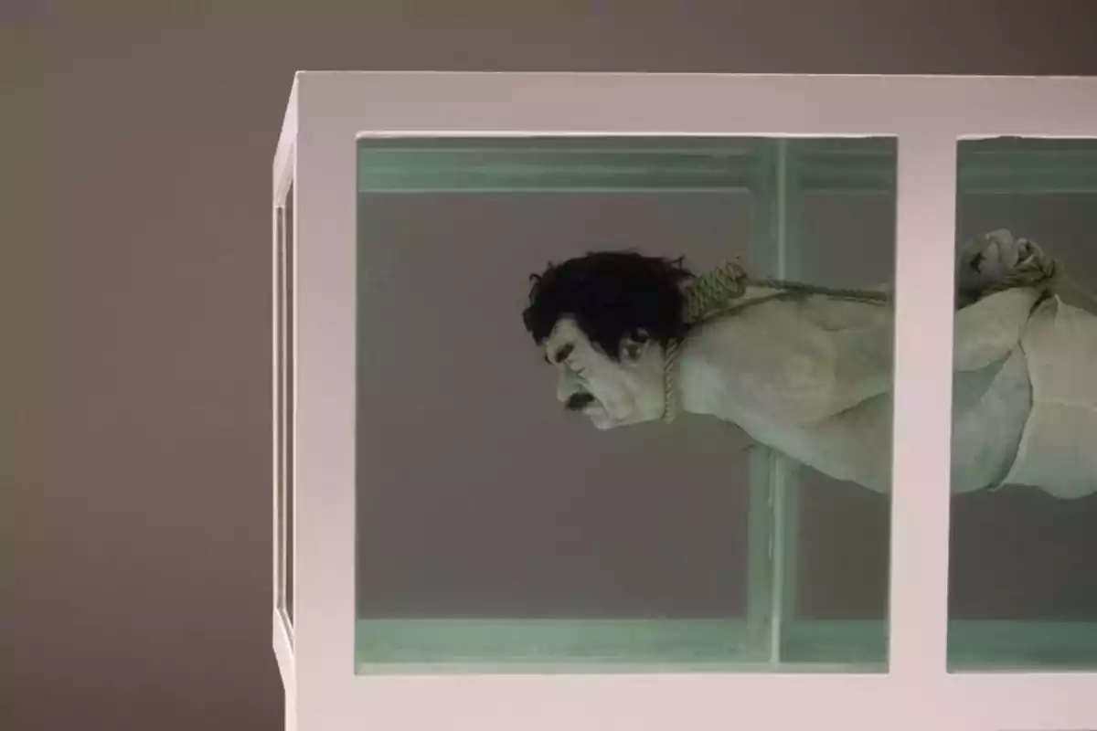 Figura humana atada y sumergida en un tanque de agua rectangular con paredes de vidrio Figura humana atada y sumergida en un tanque de agua rectangular con paredes de vidrio