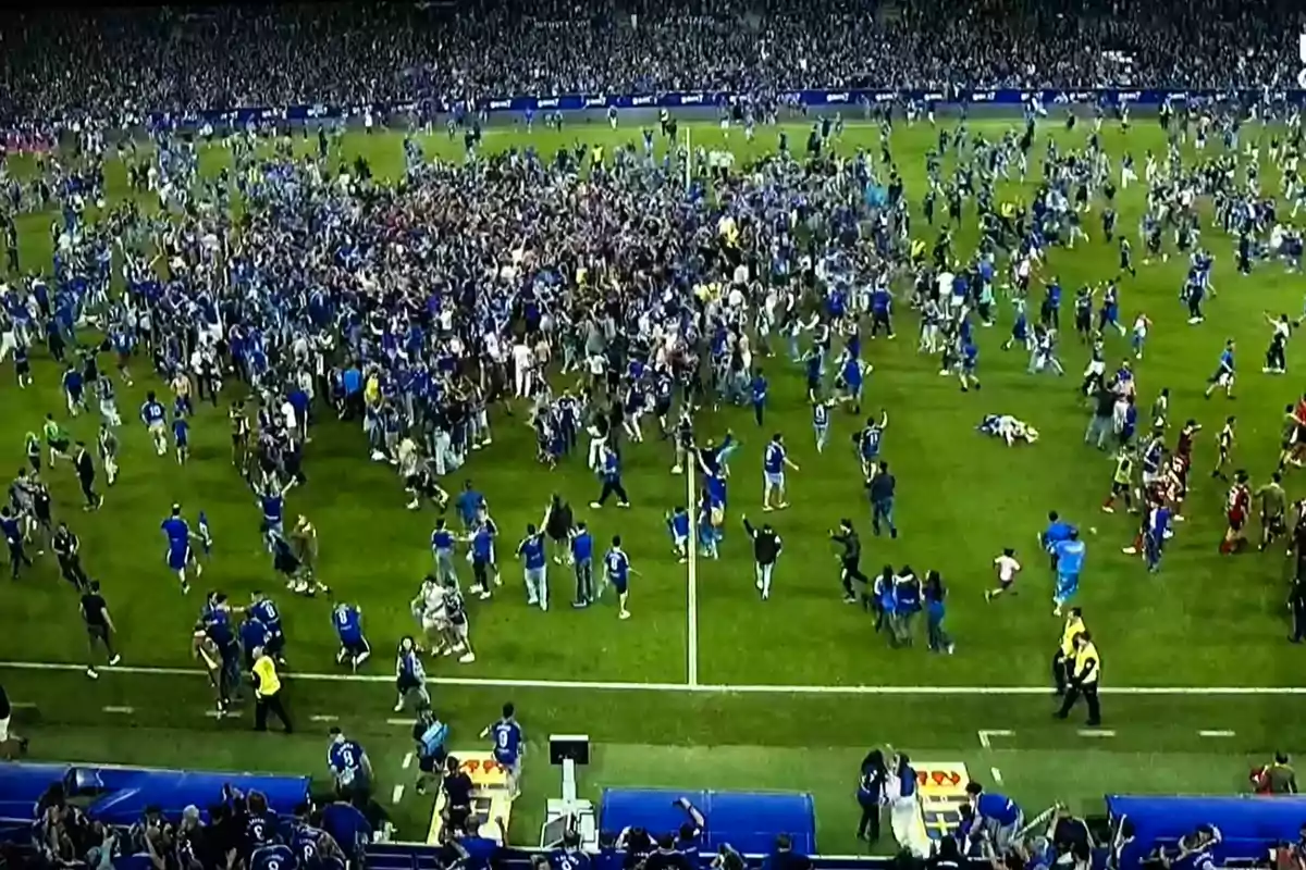 Aficionados invaden la cancha de un estadio de fútbol para celebrar un logro importante de su equipo