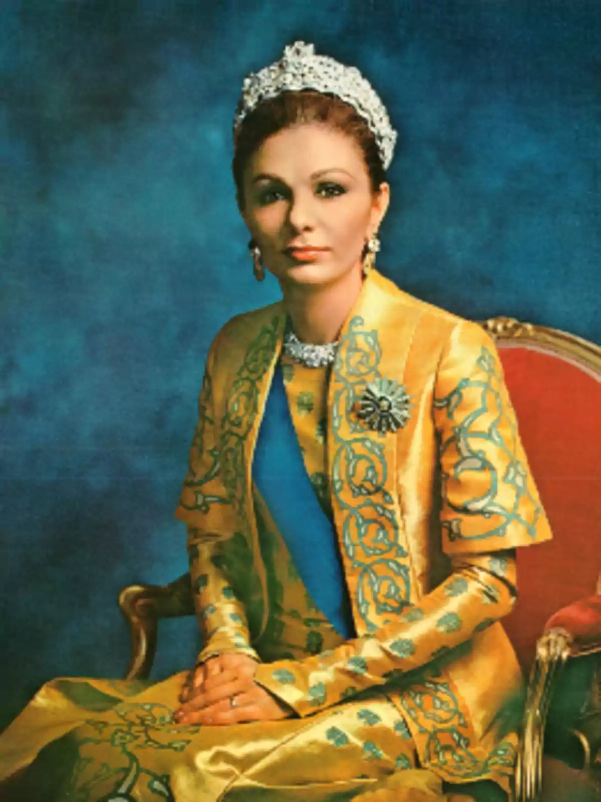 Mujer elegantemente vestida con un traje dorado y azul, sentada en una silla roja, usando una tiara y joyas, con fondo azul Mujer elegantemente vestida con un traje dorado y azul, sentada en una silla roja, usando una tiara y joyas, con fondo azul