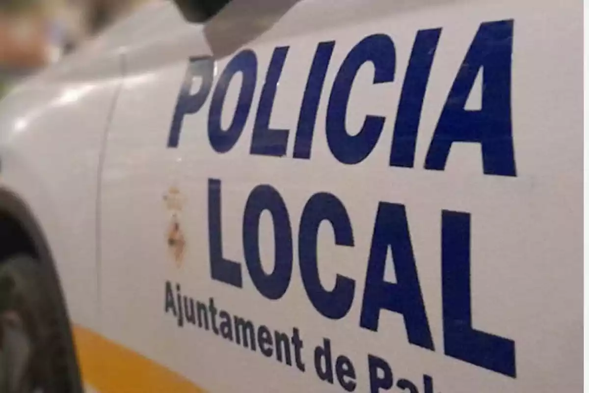 Coche de la policía local con letras azules en la puerta