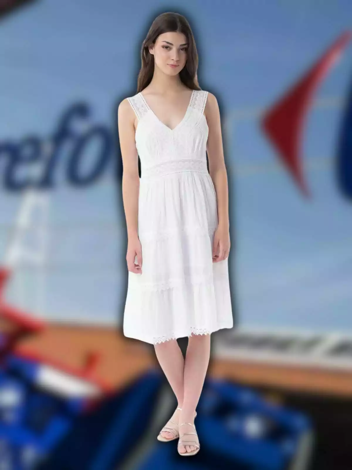 Mujer joven con vestido blanco sin mangas y sandalias posando frente a un fondo desenfocado azul y rojo Mujer joven con vestido blanco sin mangas y sandalias posando frente a un fondo desenfocado azul y rojo