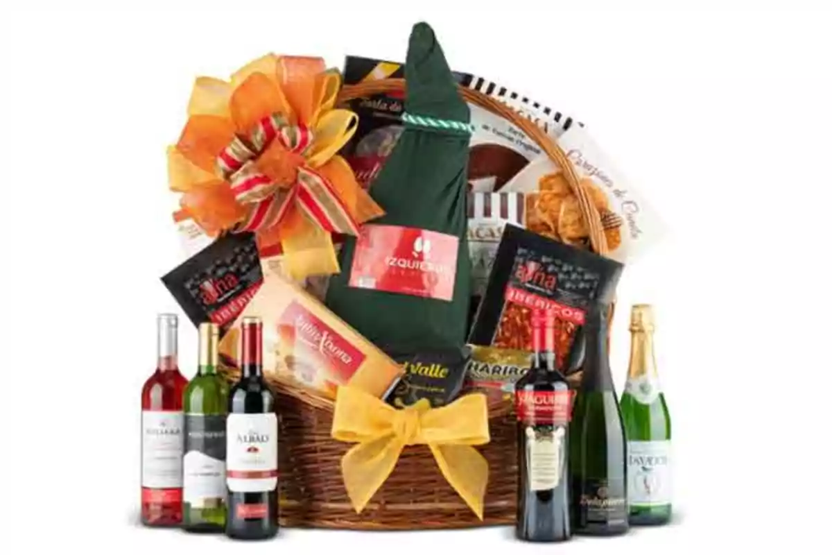 Canasta de regalo con botellas de vino, cava, embutidos, dulces y lazos decorativos