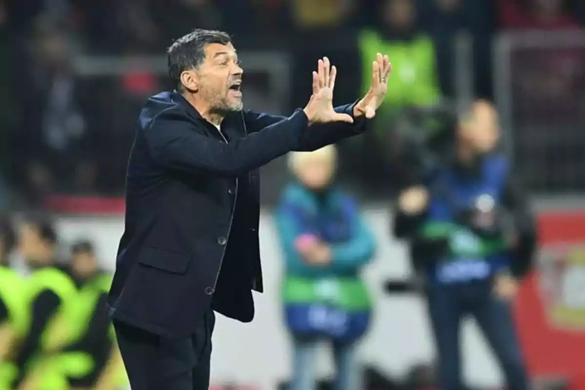 Entrenador de fútbol dando indicaciones en la banda durante un partido