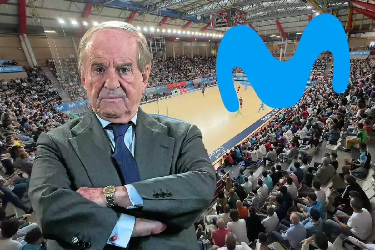 Hombre mayor de traje con los brazos cruzados en primer plano sobre un fondo de estadio lleno de espectadores y una cancha de baloncesto, con un gran logo azul de Movistar