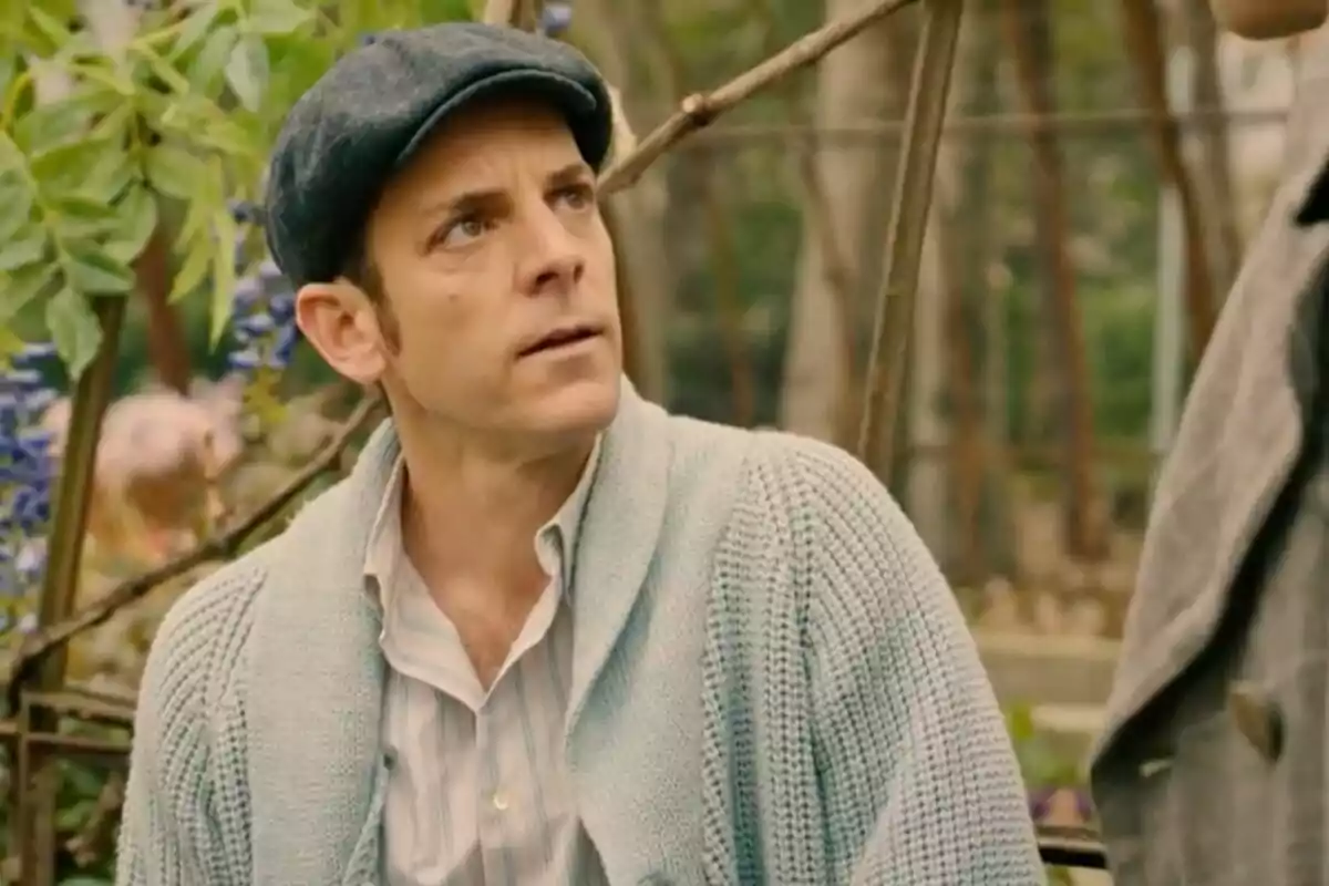 Luis Merino con gorra y suéter azul claro mirando hacia arriba en un entorno al aire libre con plantas de fondo. Luis Merino con gorra y suéter azul claro mirando hacia arriba en un entorno al aire libre con plantas de fondo.