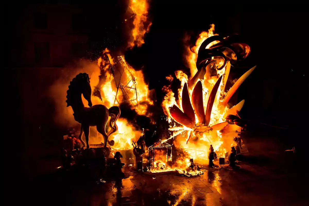 Esculturas de cartón y madera ardiendo en una gran hoguera durante la celebración de Las Fallas en Valencia
