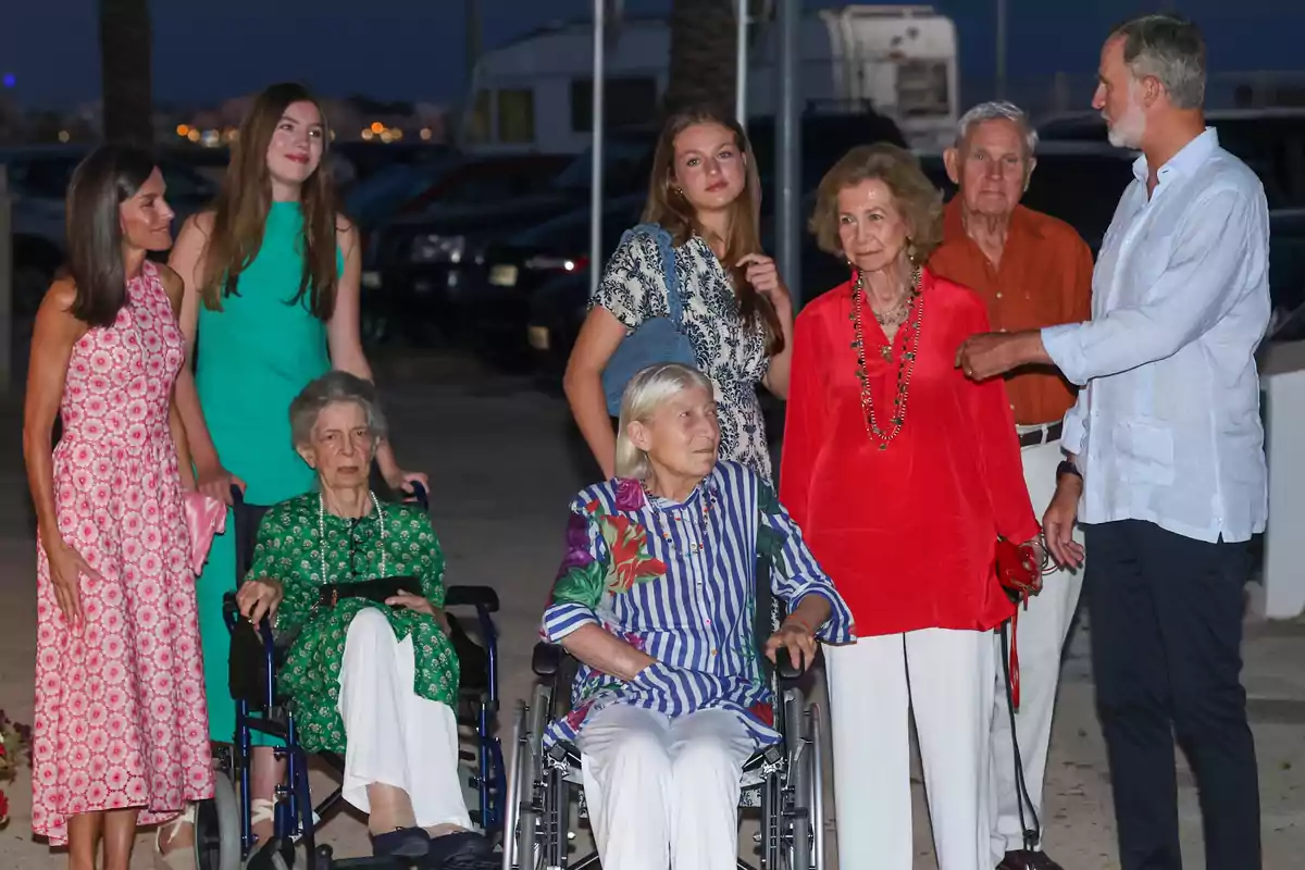 Un grupo de personas de diferentes edades, algunas en silla de ruedas, posan juntas al aire libre durante la noche, todos vestidos con ropa colorida y elegante. Un grupo de personas de diferentes edades, algunas en silla de ruedas, posan juntas al aire libre durante la noche, todos vestidos con ropa colorida y elegante.