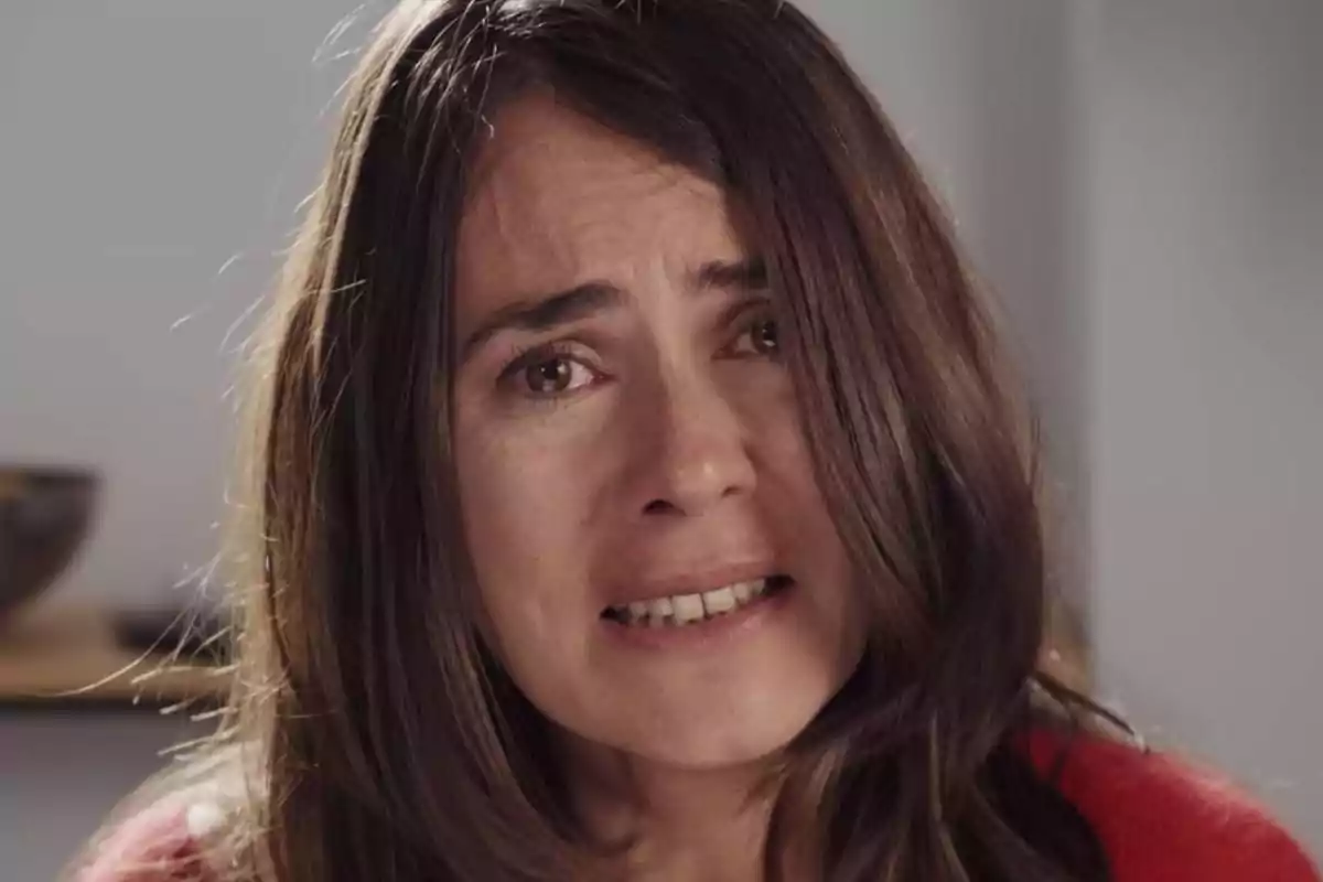 Mujer de cabello largo y castaño con expresión de tristeza y lágrimas en los ojos Mujer de cabello largo y castaño con expresión de tristeza y lágrimas en los ojos