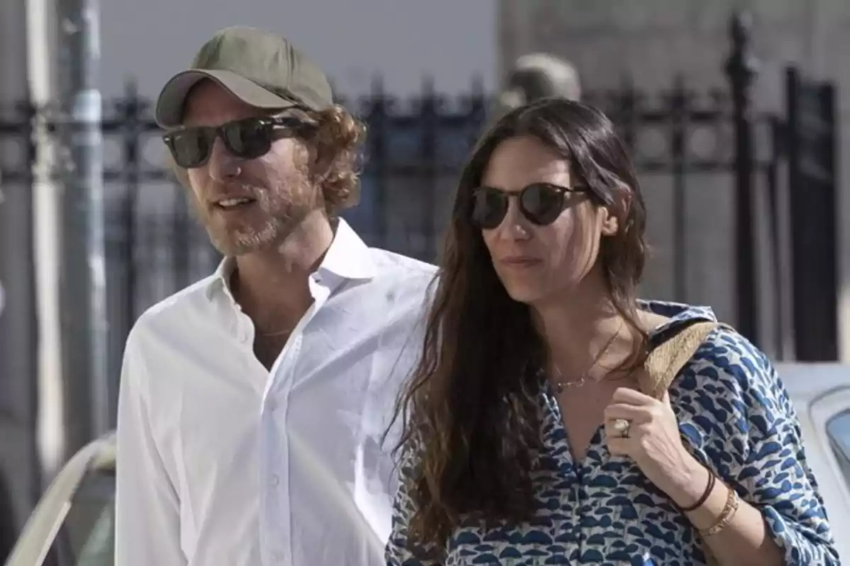 Pareja caminando al aire libre usando gafas de sol y ropa casual