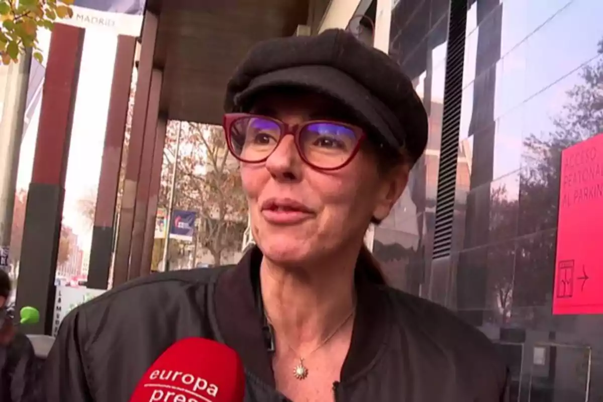 Mujer con gafas rojas y gorra negra siendo entrevistada en la calle por un medio de comunicación Mujer con gafas rojas y gorra negra siendo entrevistada en la calle por un medio de comunicación
