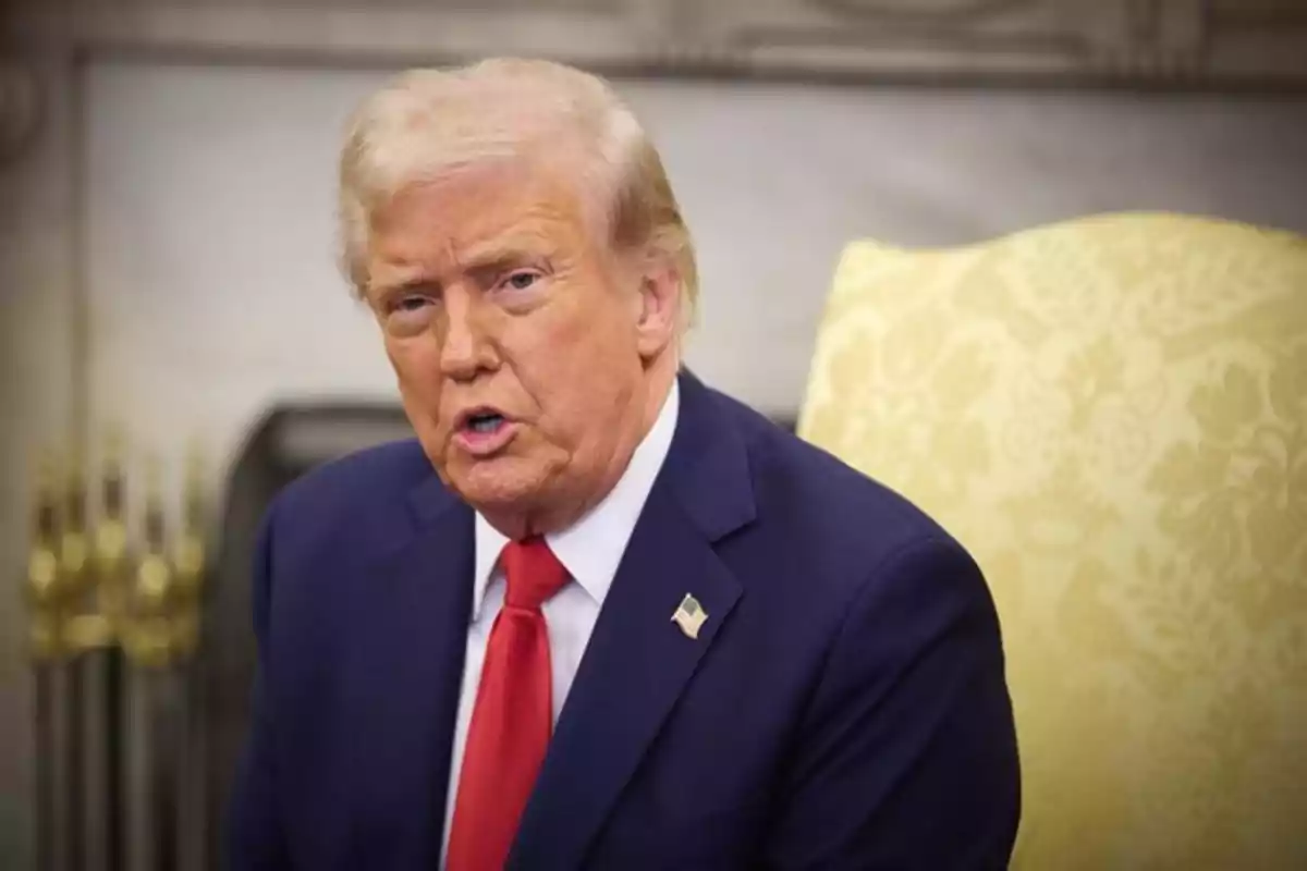 Hombre de cabello rubio con traje azul y corbata roja sentado en una silla amarilla con fondo de oficina elegante Hombre de cabello rubio con traje azul y corbata roja sentado en una silla amarilla con fondo de oficina elegante