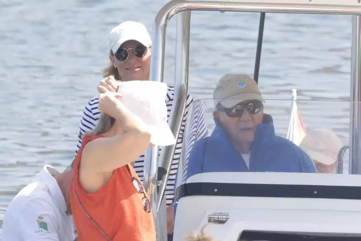 Varias personas disfrutan de un paseo en barco en un día soleado, algunas llevan gafas de sol y gorras, el agua se ve de fondo. Varias personas disfrutan de un paseo en barco en un día soleado, algunas llevan gafas de sol y gorras, el agua se ve de fondo.